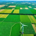 A breathtaking aerial view of lush green fields with a backdrop of orderly windmills generating renewable