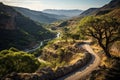 Breathtaking aerial view of serpentine road and mountain river in gorge at sunset