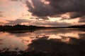 Breathtaking dark sunset cloudscape and its reflection in the river Royalty Free Stock Photo