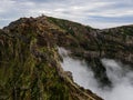 Breathtaking hiking trail with a view of a beautiful mountain landscape above the clouds of Madeira Island - Green