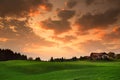 Breathtaking lansdcape of Austrian countryside on sunset. Dramatic sky over idyllic green fields of Anstrian Central Alps on autum