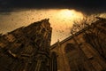 Breathtaking low angle shot of a tall gothic cathedral with stained glass windows under a gloomy sky