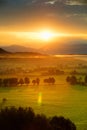 Breathtaking morning lansdcape of small bavarian village covered in fog. Scenic view of Bavarian Alps at sunrise with majestic mou Royalty Free Stock Photo