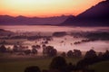 Breathtaking morning lansdcape of small bavarian village covered in fog. Scenic view of Bavarian Alps at sunrise with majestic mou