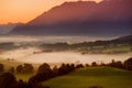 Breathtaking morning lansdcape of small bavarian village covered in fog. Scenic view of Bavarian Alps at sunrise with majestic mou Royalty Free Stock Photo