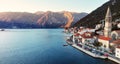 Breathtaking panoramic sunset aerial drone view of the ancient city of Perast, Montenegro. Old medieval little town with red roofs