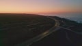 Breathtaking pink sunset sky over coastline drone view. Road running seashore Royalty Free Stock Photo