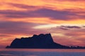 Breathtaking scenery of a rocky cliff in the sea under a sunset sky Royalty Free Stock Photo