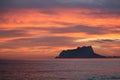 Breathtaking scenery of a rocky cliff in the sea under a sunset sky Royalty Free Stock Photo