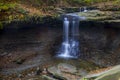 Breathtaking scenery of a strong waterfall in the middle of an autumn forest