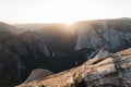 Breathtaking scenery of the sun rising over a rock formation covered in greenery