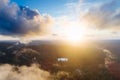 Breathtaking scenery of the sun rising over a rock formation covered in greenery