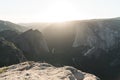 Breathtaking scenery of the sun rising over a rock formation covered in greenery