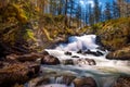Breathtaking shot of an idyllic waterfall flowing through mossy rocks in a peaceful forest Royalty Free Stock Photo