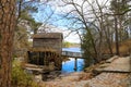 a breathtaking shot of the old wooden grist water mill at Stone Mountain Park with vast blue lake water Royalty Free Stock Photo