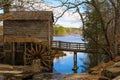 a breathtaking shot of the old wooden grist water mill at Stone Mountain Park with vast blue lake water Royalty Free Stock Photo