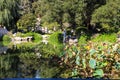 A breathtaking shot of a a stone bridge over a like with deep green lake water and lush green trees reflecting off the lake with b Royalty Free Stock Photo