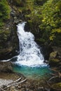 Breathtaking shot of a waterfall in a forest surrounded by rocks and trees