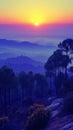 Breathtaking sunrise unfolds over misty hills and pine trees, painting the sky with hues of purple, orange, and yellow. Royalty Free Stock Photo