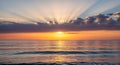 A scenic view of the ocean at sunset with sun rays peeking through the clouds above the horizon line video 4k Royalty Free Stock Photo