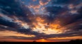 Dramatic sunset with vibrant orange and dark clouds over a silhouetted landscape image photo Royalty Free Stock Photo