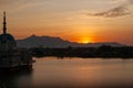 Breathtaking sunset view of a majestic mosque situated on a tranquil body of water