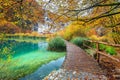 Breathtaking tourist pathway in colorful autumn forest, Plitvice lakes, Croatia Royalty Free Stock Photo