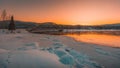 Breathtaking view of a bridge over snow covered field and frozen lake at sunset captured in Sweden Royalty Free Stock Photo