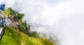 Breathtaking view cable car climbing up Steep Craggy Cliff in thick creeping fog atmosphere