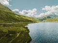 Breathtaking view of green Scottish highlands next to a sea with a cloudy sky