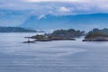 Breathtaking view of a lighthouse on the small island in the sea in Alesund Cruise Port, Norway Royalty Free Stock Photo