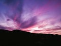 Breathtaking view of pink and purple clouds during the sunset above the mountains Royalty Free Stock Photo