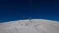 Breathtaking view of a snow-capped mountain in the Dolomites, with a chairlift. The majestic peaks loom in the distance, blanketed