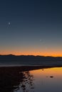 Breathtaking view of a tranquil night sky, with crescent moon setting over a silhouette of mountains