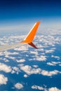 Breathtaking view. The wing of a small scheduled plane against the blue sky, clouds of the sea surface below. View from the Royalty Free Stock Photo