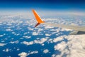 Breathtaking view. The wing of a small scheduled plane against the blue sky, clouds of the sea surface below. View from the Royalty Free Stock Photo