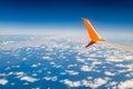 Breathtaking view. The wing of a small scheduled plane against the blue sky, clouds of the sea surface below. View from the Royalty Free Stock Photo