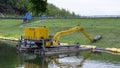 Brebes, Indonesia - Dec 12, 2021: A yellow excavator floating on water. This machine is heavy equipment used in the construction