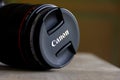 Brecht, Belgium - April 30 2020: A portrait of a canon DSLR 100mm macro lens lying on a wooden table in a living room indoors. The