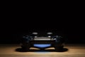 Brecht, Belgium - August 10 2019: A portrait of a turned on Sony Playstation 4 controller in the spotlight with darkness around it