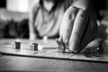 Brecht, Belgium - 28 july 2020: The fingers of a hand of a person reaching out holding the metal dinosaur pawn or game piece of a