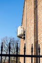 Brecht,Belgium - March 4 2022: An air conditioning unit hanging outside of a building on a brick wall, to regulate the temperature