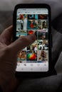 Brecht, Belgium - November 14 2019: A user holding a smartphone in one hand using the thumb to browse/scroll through the instagram