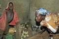 Breeding chicks by Ugandan woman with son