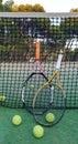 Brela. Croatia - Augest 9, 2019: Tennis rackets and balls on an outdoor court in summer near the net against a pine forest
