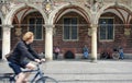 Bremen, Germany - 07/23/2015 - Cyclist rides in front the city hall in the historical center of Bremen, people sitting on a bench