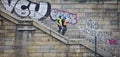 Bremen, Germany - March 8th, 2017 - Two construction workers with hi-viz vests and helmets walking down a set of stairs in front o