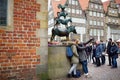 BREMEN, GERMANY - MARCH 23, 2016: Tourists taking pictures of themselves by famous statue in the center of Bremen, known as The Br