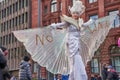 Woman on stilts with white costume and the writing `no war`