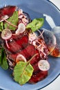 Bresaola, thinly sliced with lettuce italiana cured salted beef in a plate with sauce and beetroot leaves close-up Royalty Free Stock Photo